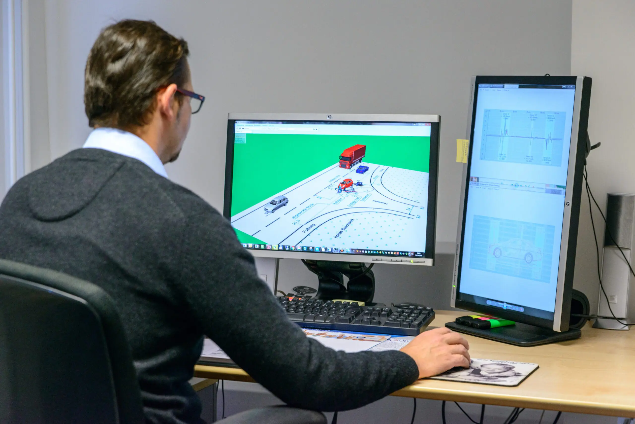 Ein Unfallrekonstruktion Sachverständiger sitzt am PC und führt für Kfz eine digitale Unfallanalyse durch.